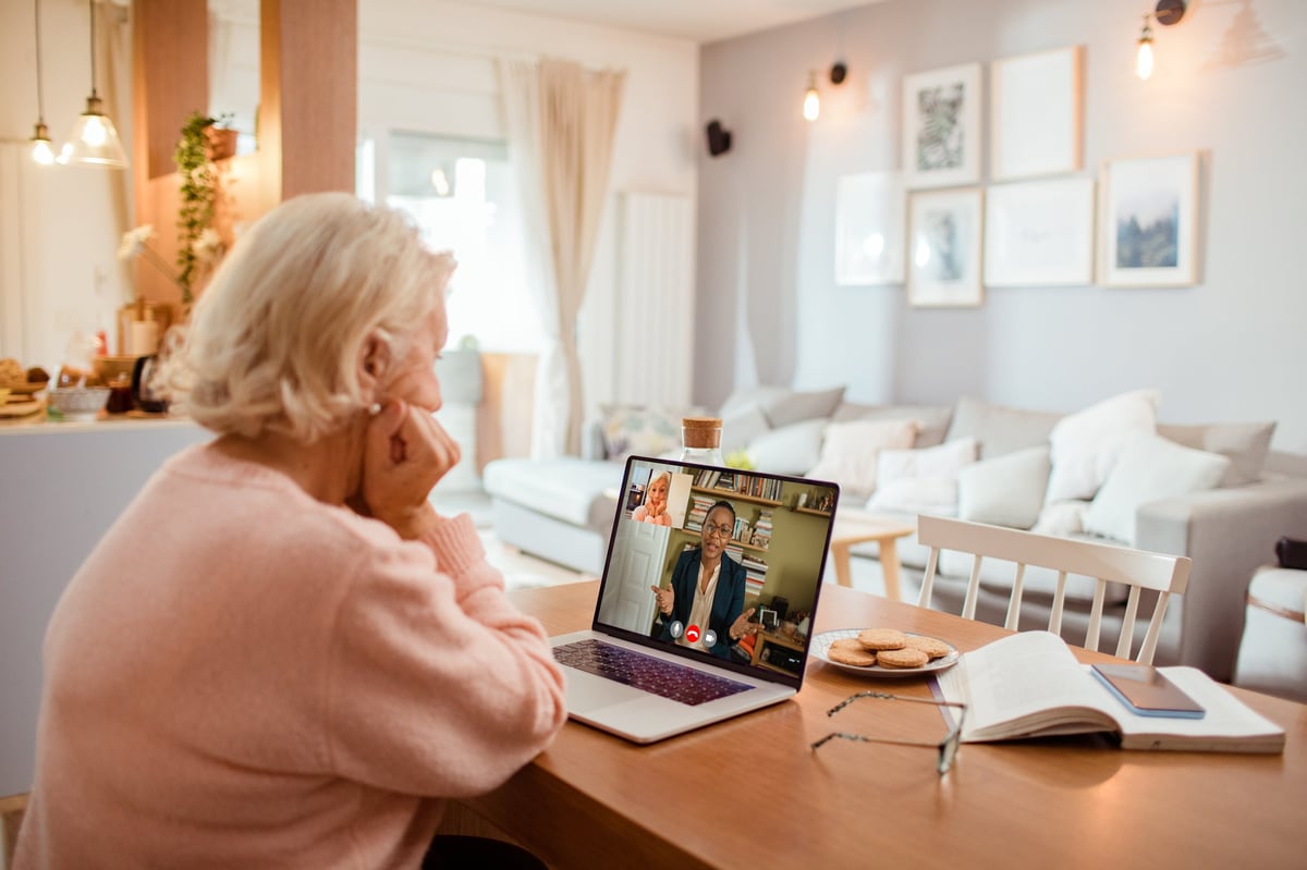 A senior woman speaking with her counselor over a video call